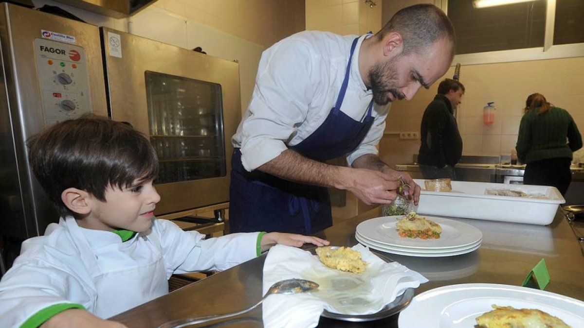 Uno de los participantes prepara su tapa bajo la atenta mirada de su pequeño ayudante.-ISRAEL L. MURILLO