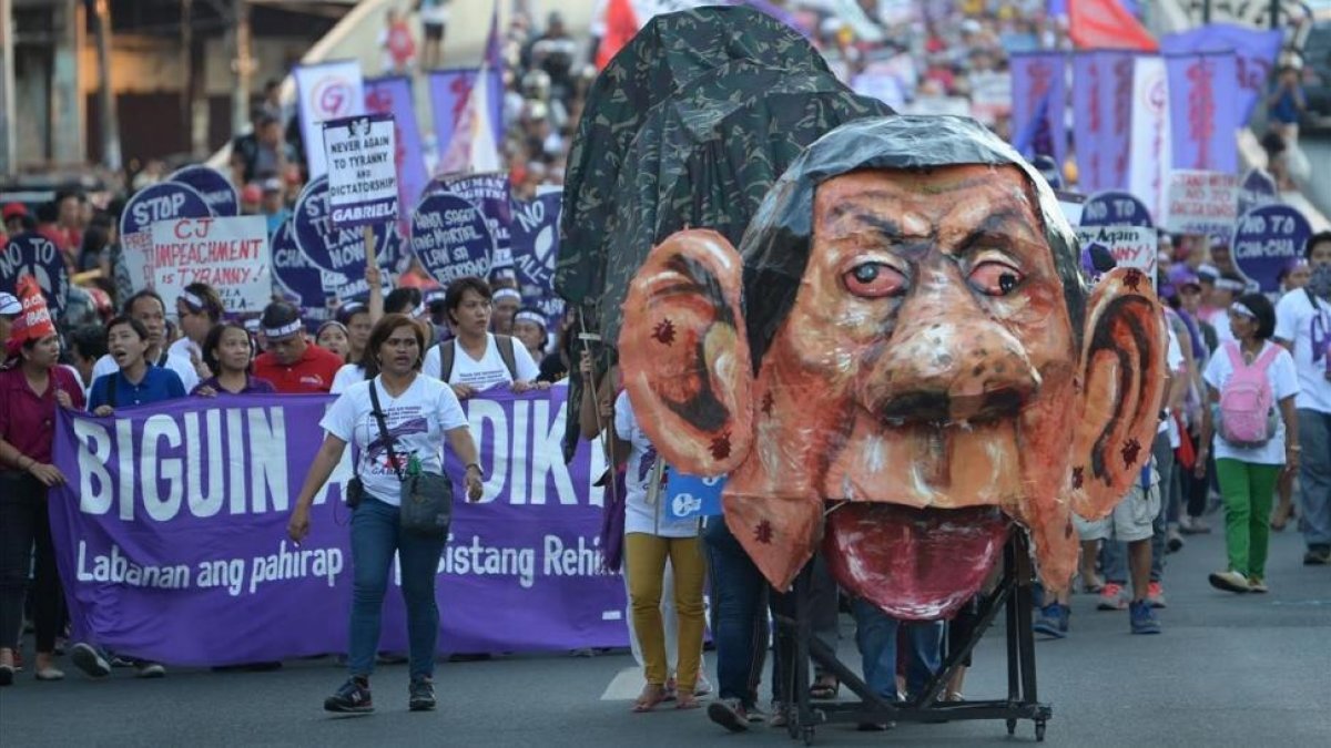 Manifestantes en Manila durante el Día Internacional de la Mujer empujando una efigie del presidente filipino, Rodrigo Duterte-/ TED ALJIBE (AFP)