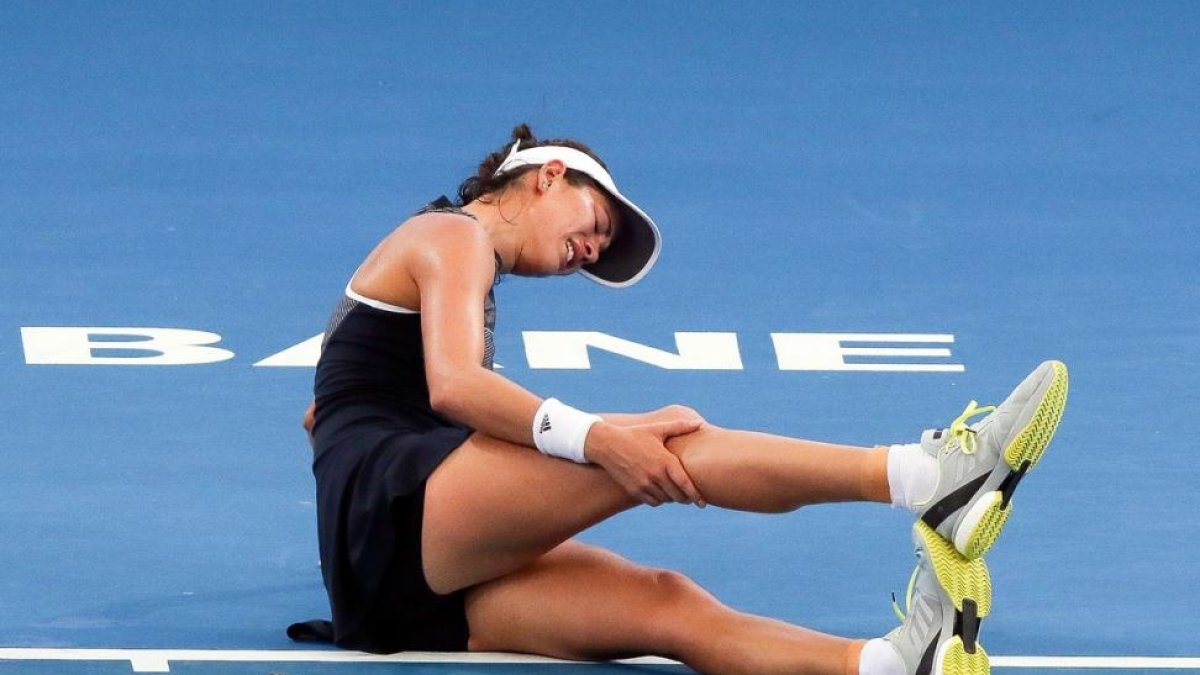 Garbiñe Muguruza se queja en el suelo de sus problemas en las piernas.-AFP