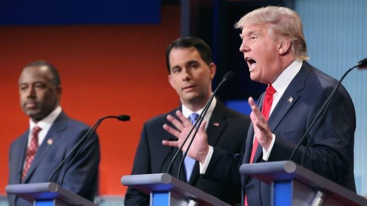 Donald Trump, durante una intervención, observado por Scott Walker y Ben Carson, anoche en Cleveland.-AFP