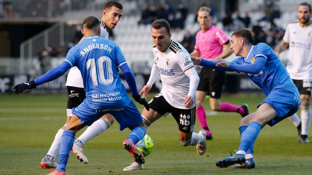 Pablo Valcarce conduce el balón entre dos jugadores del Fuenlabrada. SANTI OTERO