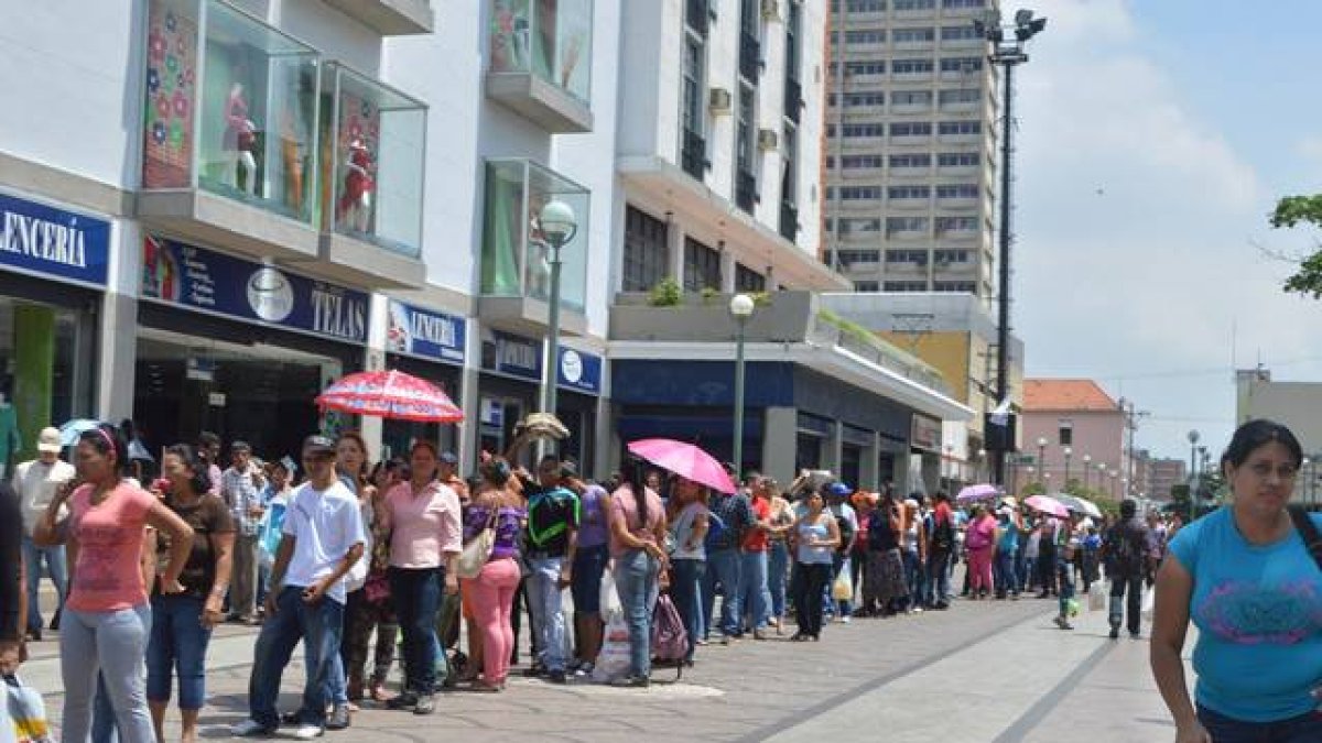 Colas de venezolanos ante un establecimiento de Caracas.-
