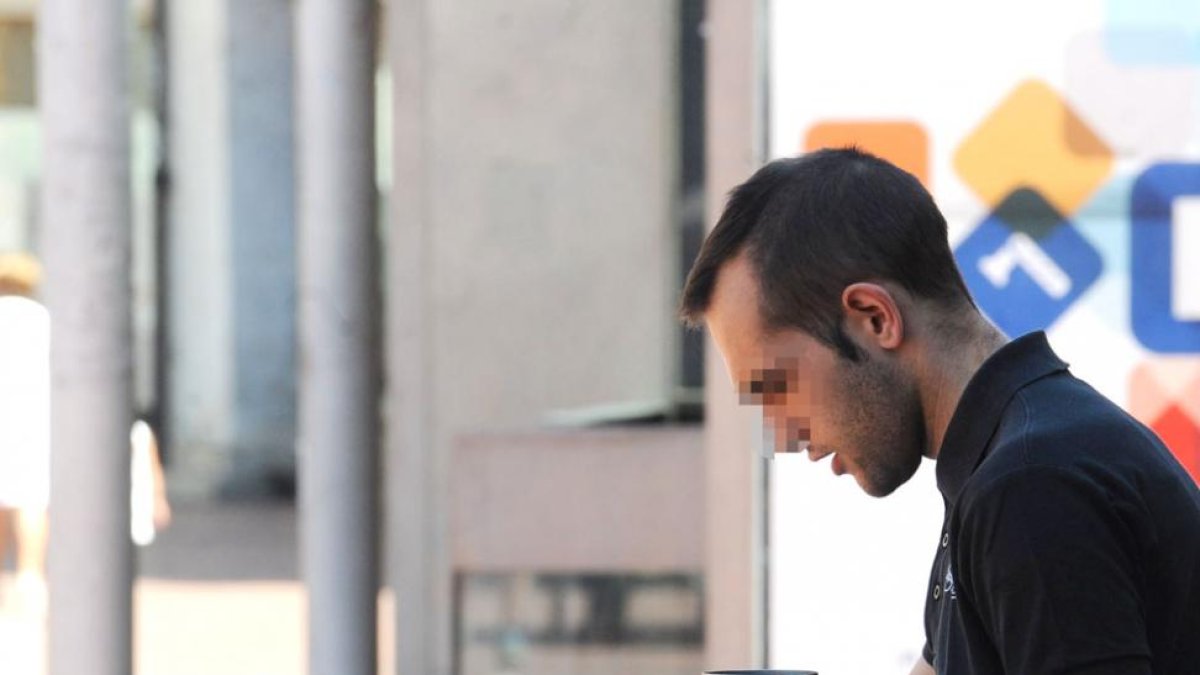 Un camarero da el cambio a una mujer en la terraza de un establecimiento.-ISRAEL L. MURILLO