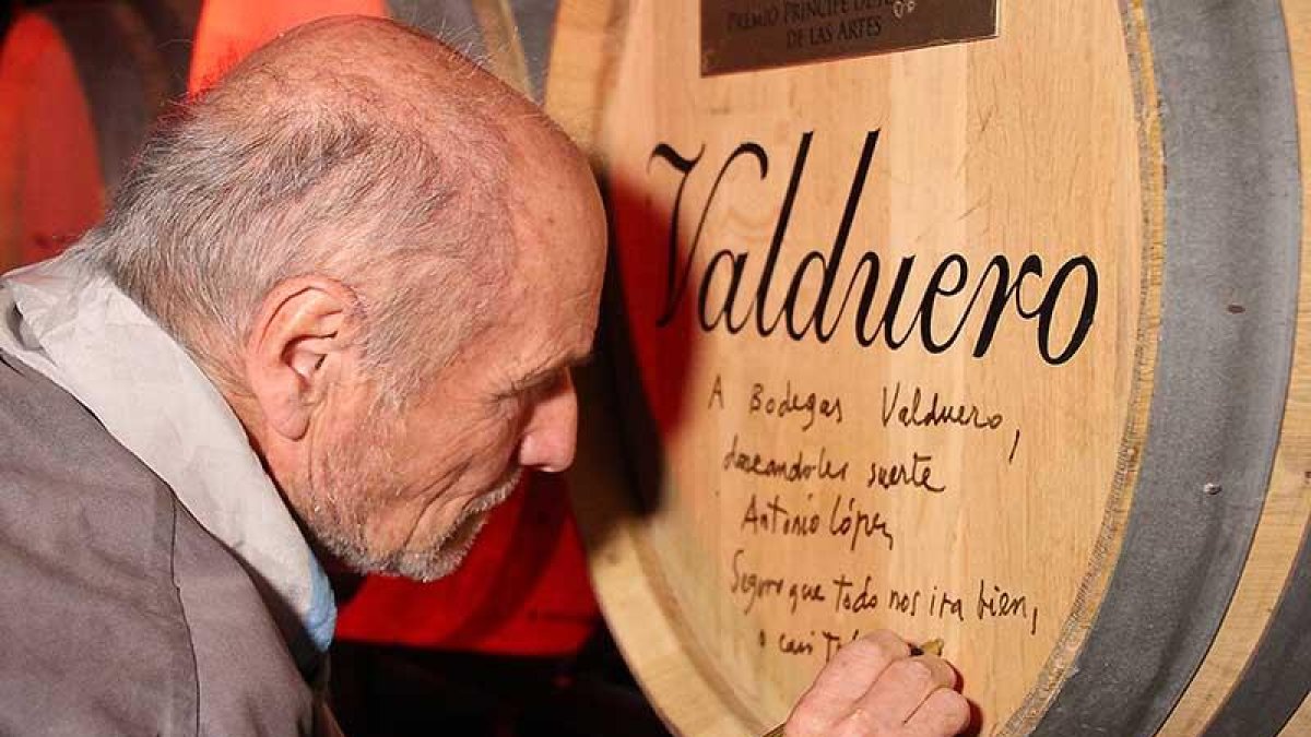 Antonio López escribe una dedicatoria en una de las barricas de la bodega.-ECB
