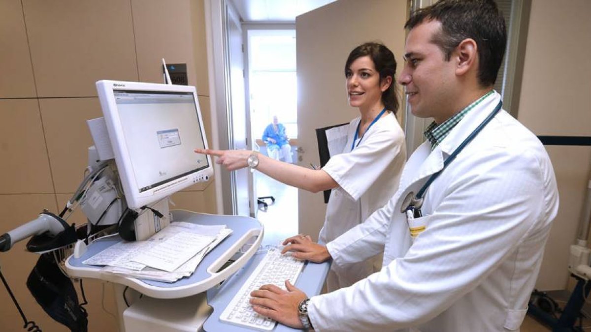 Un médico y una residente utilizan uno de los ordenadores del servicio de Medicina Interna del Hospital Universitario de Burgos-R. OCHOA