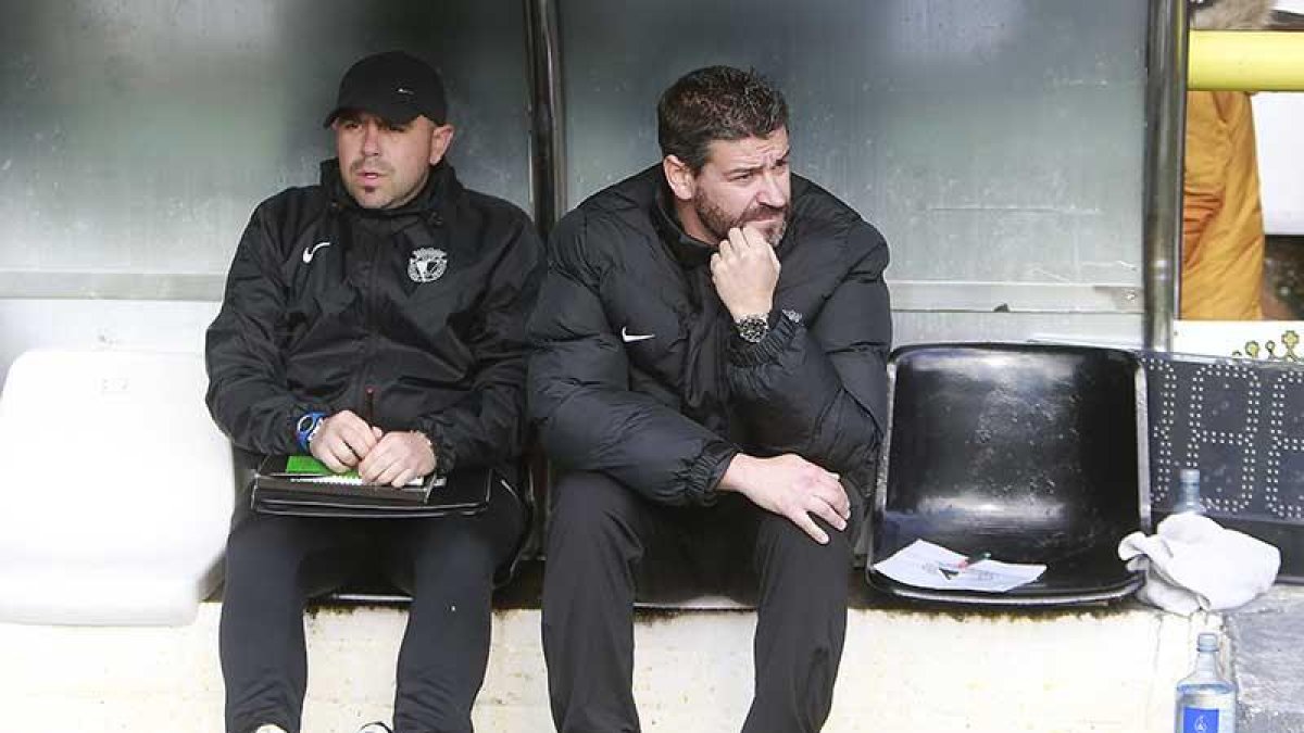 Fernando Estévez, pensativo en el banquillo del Burgos CF junto a su ayudante Óscar Río-Raúl G. Ochoa
