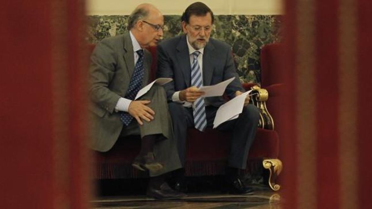 Montoro y Rajoy estudian unos papeles durante un pleno en el Congreso.-JOSÉ LUIS ROCA