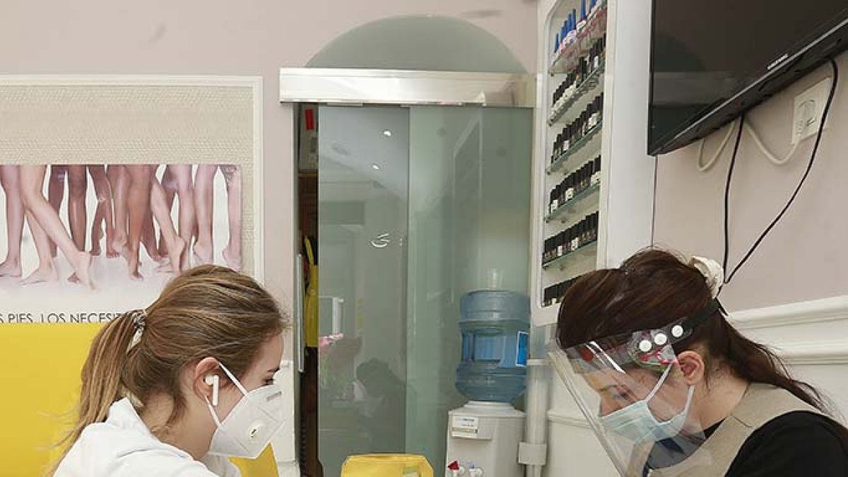 Una trabajadora del sector Servicios de Burgos, atiende a una clienta aplicando las medidas contra el Covid 19. S. O.