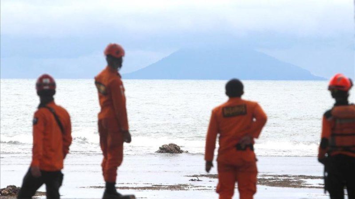 Miembros de los servicios de rescate observan la actividad del volcán Anak Krakatau desde la playa indonesia de Carita.-ADI WEDA (EFE)