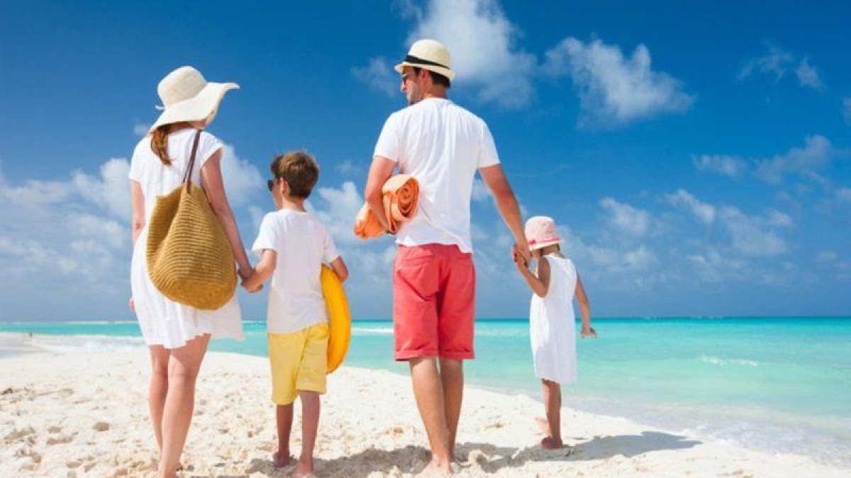 Una familia disfruta de unas vacaciones en una playa paradisiaca.-SHUTTERSTOCK