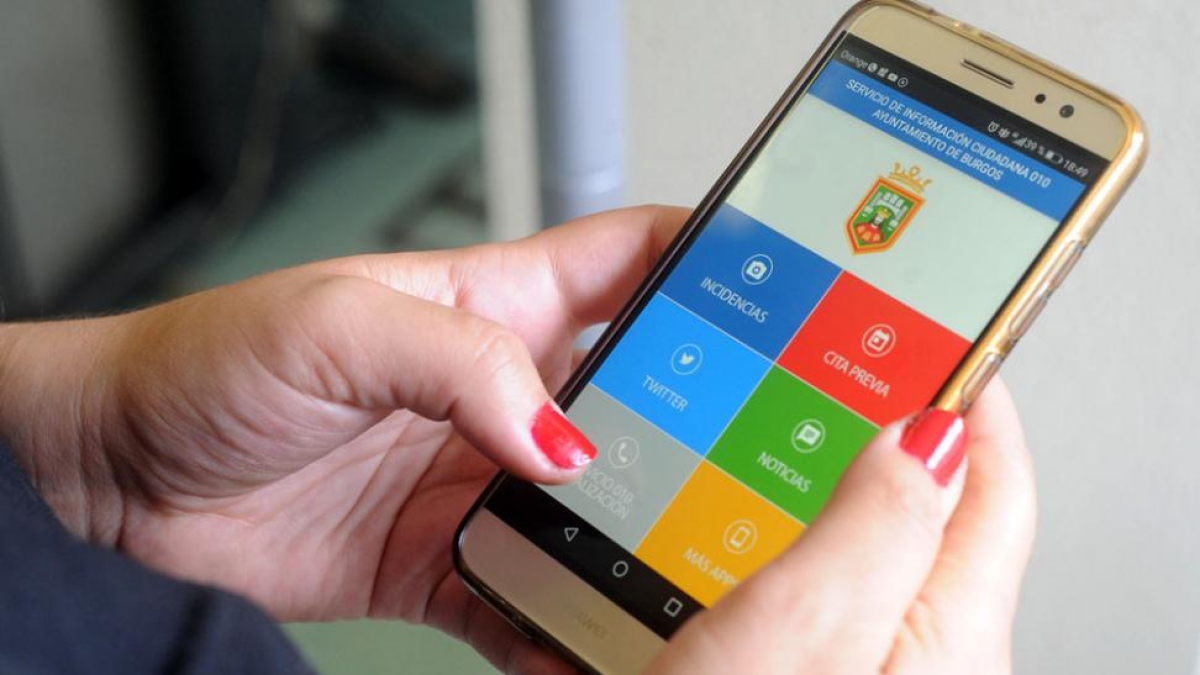 Una mujer consulta la aplicación Burgos al móvil que integra el servicio 010.-ISRAEL L. MURILLO