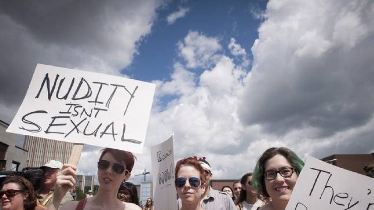 Manifestantes en la ciudad de Waterloo este domingo protestando por su derecho en Canadá de hacer toples.-Foto:   AP / HANNAH YOON