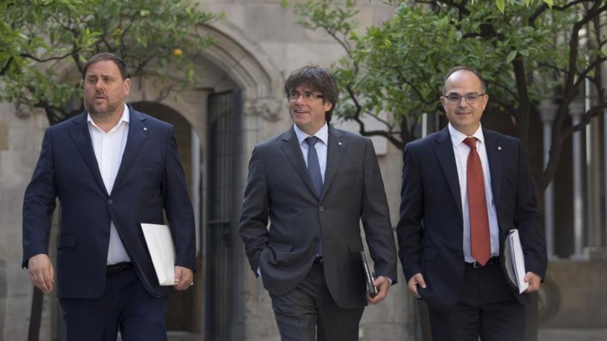 El president Carles Puigdemont, entre el vicepresidente Oriol Junqueras y el conseller Jordi Turull, en el Palau de la Generalitat-ALBERT BERTRAN