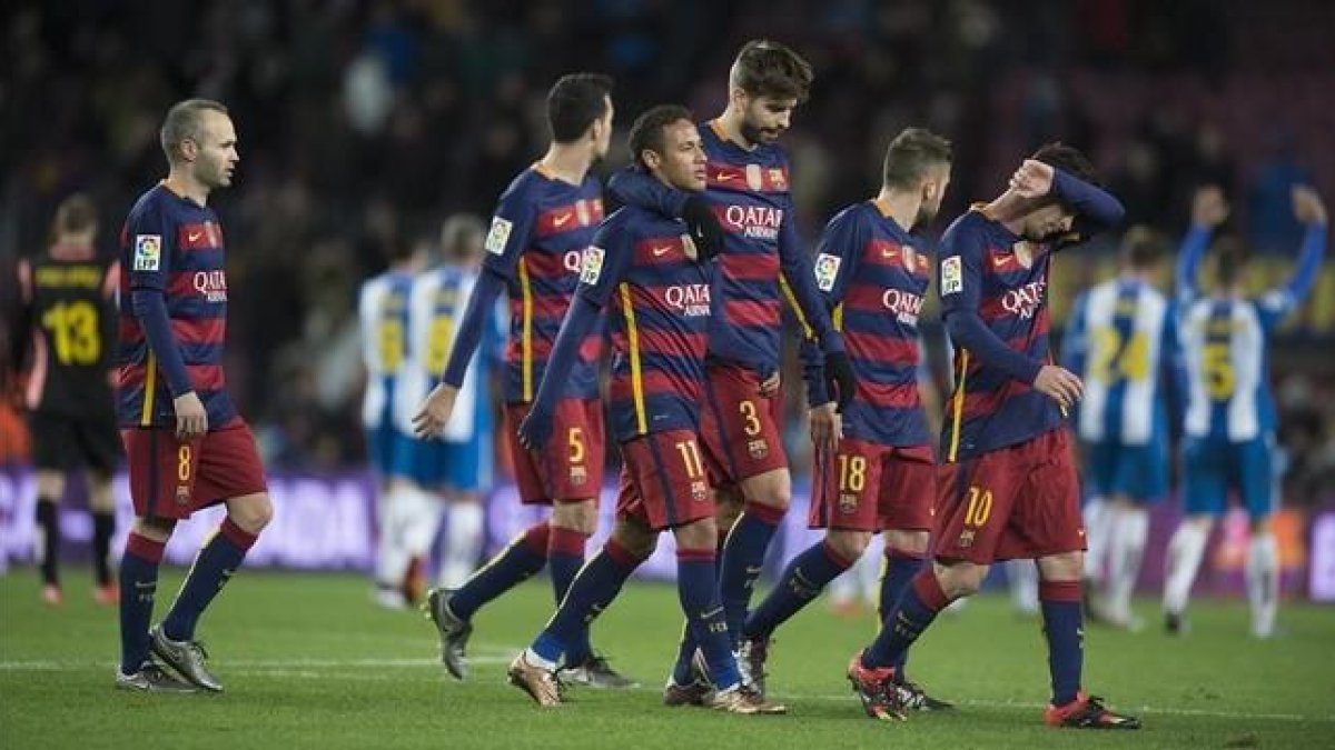 Los jugadores del Barça regresan a los vestuarios mientras los del Espanyol saludan a su afición en el Camp Nou.-