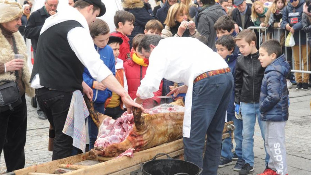 Un grupo de niños observa con atención como se realiza el despiece del cerdo.-ISRAEL L. MURILLO