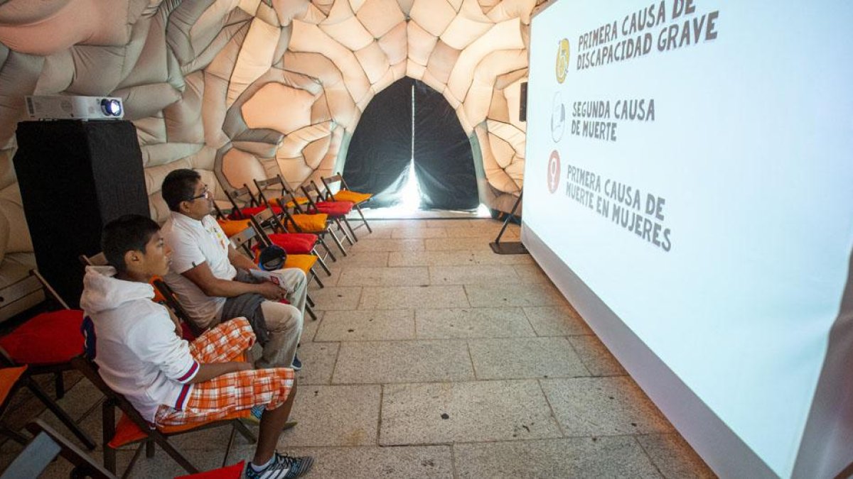 Un par de jóvenes observan el vídeo de presentación en el interior del cerebro ‘itinerante’.-SANTI OTERO