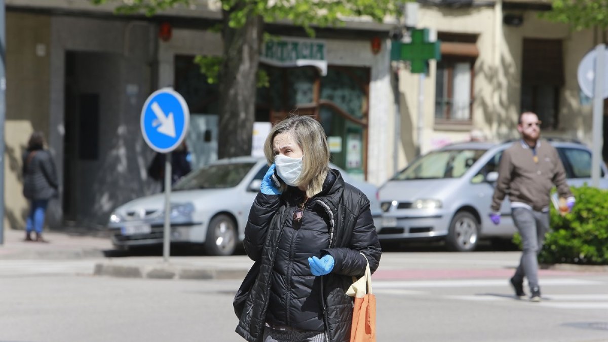 Una mujer con mascarilla y guantes. RAÚL OCHOA