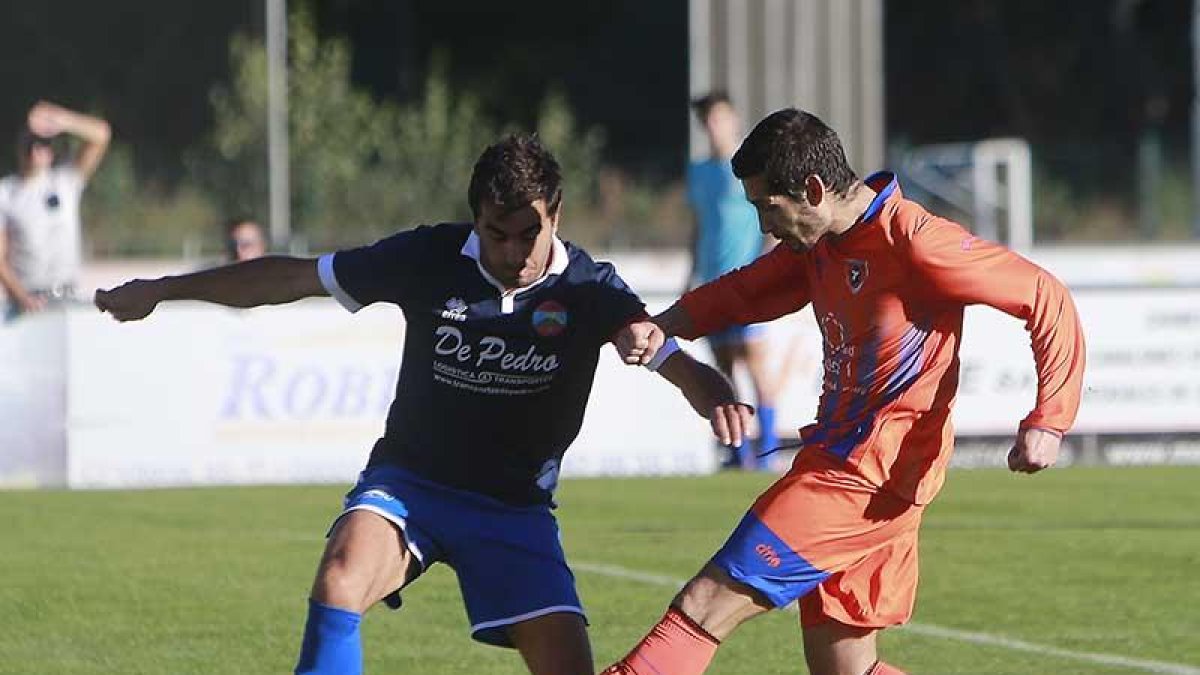 Soto intenta hacerse con un balón ante la presencia de un defensor del Sporting Uxama-Raúl G. Ochoa
