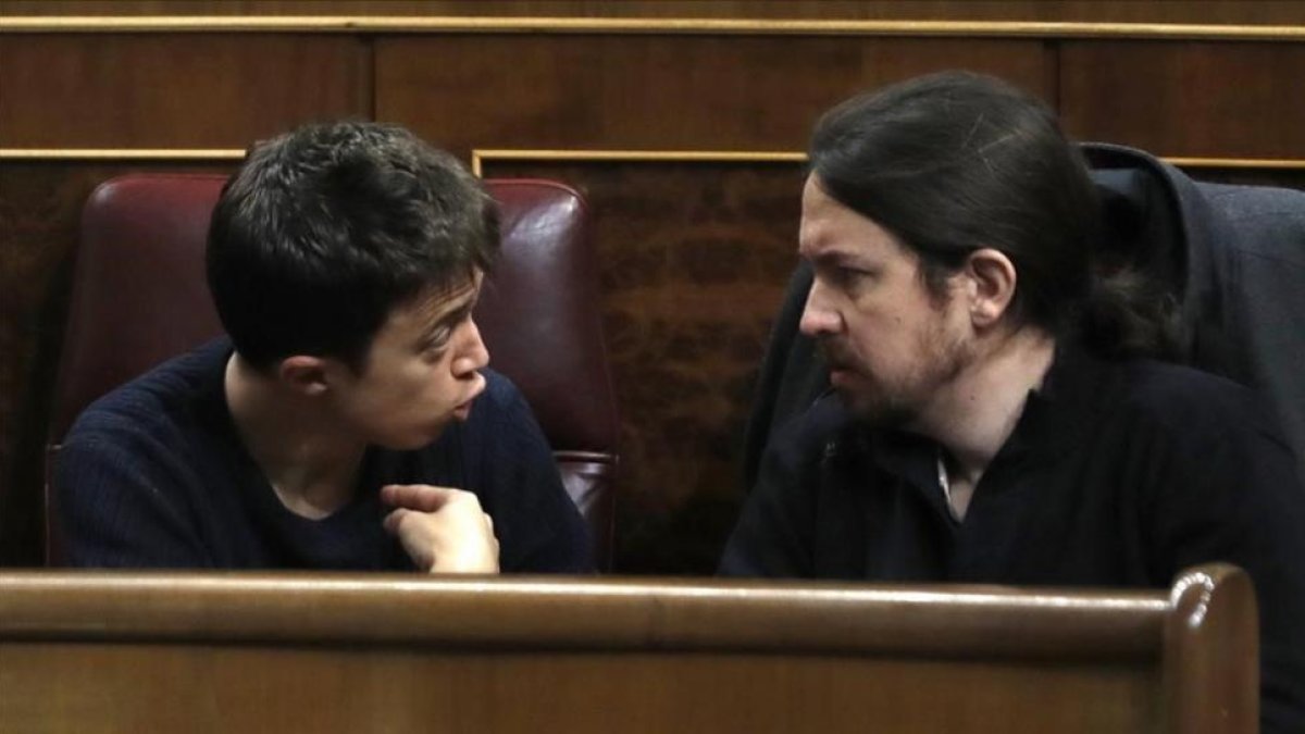 Los máximos dirigentes de Podemos, Iñigo Errejón y Pablo Iglesias, discuten en sus escaños del Congreso.-EMILIO NARANJO / EFE