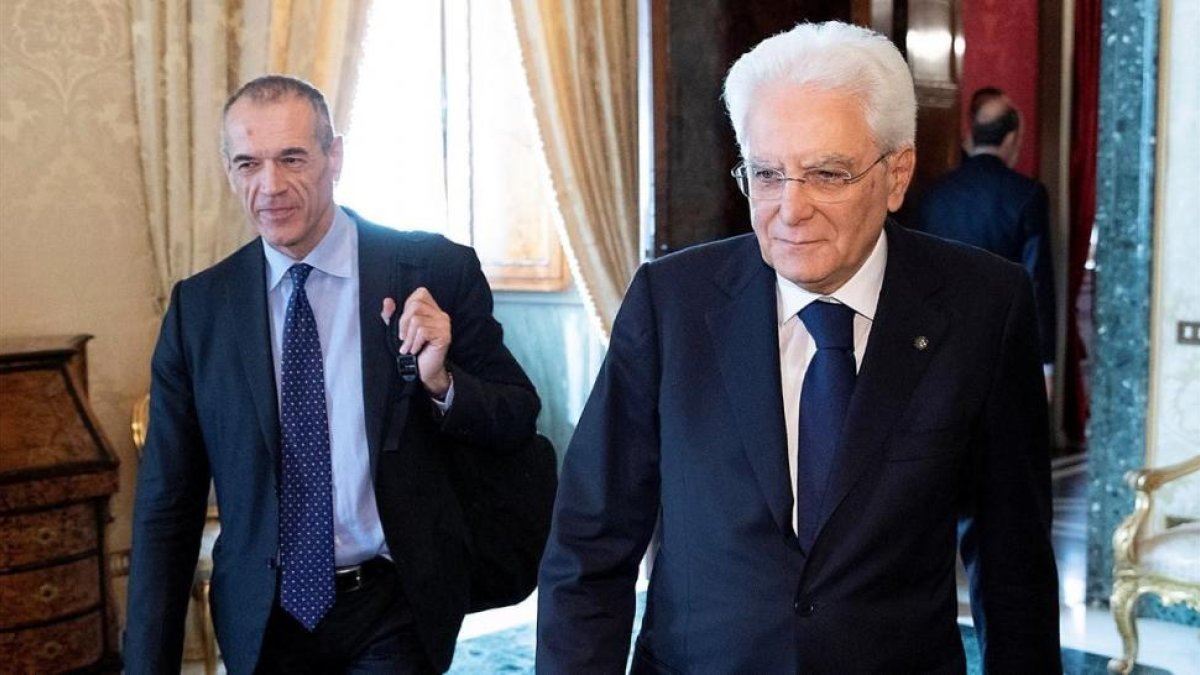 El presidente italiano, Sergio Mattarelli, en primer plano, junto a Carlo Cottarelli en el Palacio del Quirinal.-REUTERS