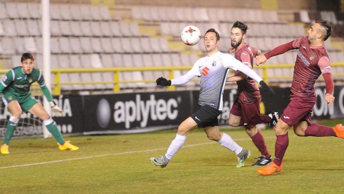 Carlos Álvarez, que ayer acabó con su sequía goleadora, pelea por un balón perseguido por dos defensores del Pontevedra-Israel L. Murillo