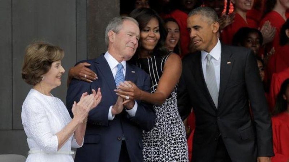 La primera dama, Michelle Obama, abraza al expresidente George Bush, en el momento de llegar con Obama a la inauguración del museo de África inaugurado en Washington.-REUTERS / JOSHUA ROBERTS