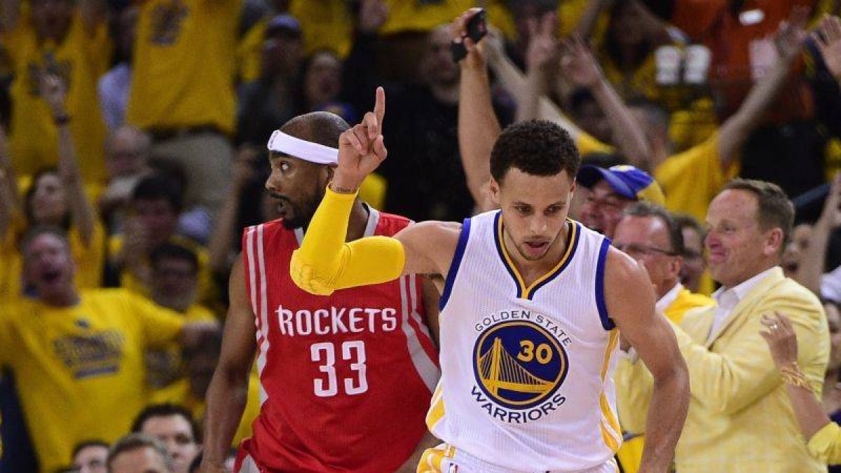 El jugador de los Warriors de Golden State Stephen Curry (c) celebra tras encestar contra los Rockets de Houston, durante el quinto partido de las finales de la Conferencia.-Foto: EFE