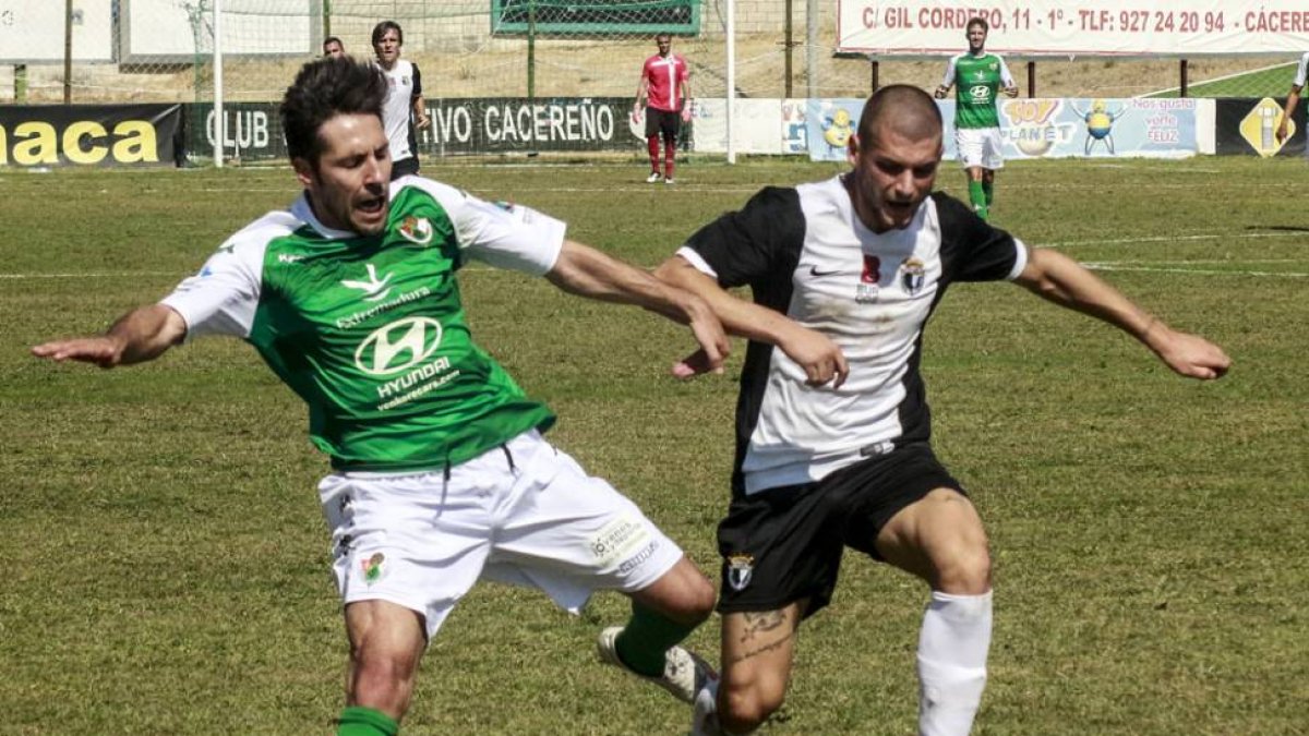 Aitor Granados protege el balón ante un jugador del Cacereño, ayer-CARLOS CASARES / EL PERIÓDICO DE EXTREMADURA