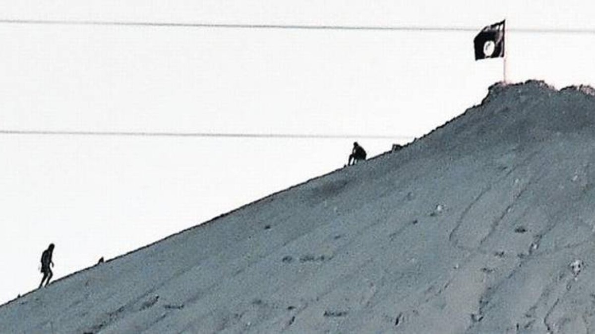 La bandera del EI ondea en una colina junto a Kobani, el lunes.-Foto: REUTERS / UMIT BEKTAS / AFP / ARIS MESSINIS