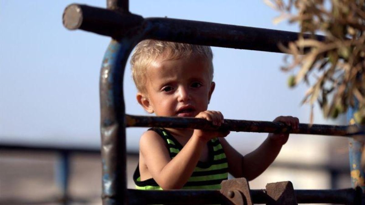 Un niño sirio llega con su familia al campo de refugiados de Idleb, en Siria.-KHALIL ASHAWI (REUTERS)