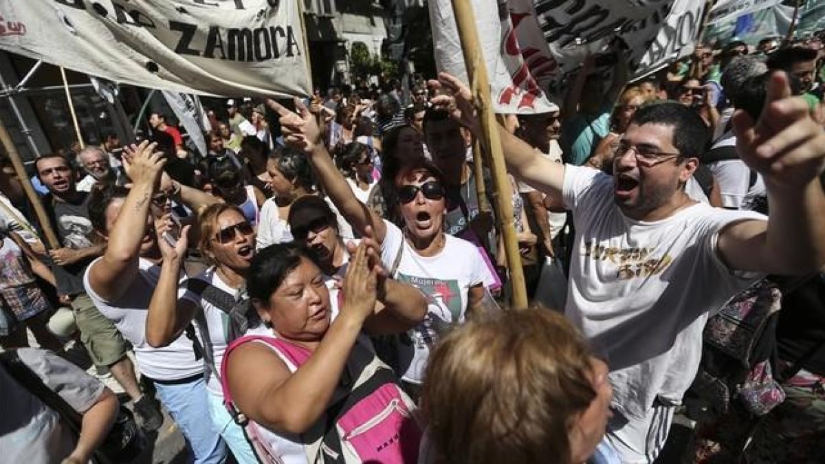 Un grupo de personas se manifiestan en el centro de Buenos Aires, en protesta por los despidos masivos de trabajadores estatales, este miércoles.-EFE / DAVID FERNÁNDEZ