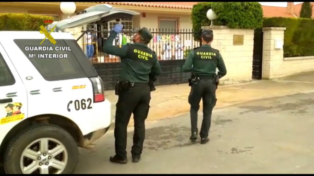 Dos guardias entregan material de protección en una residencia. ECB
