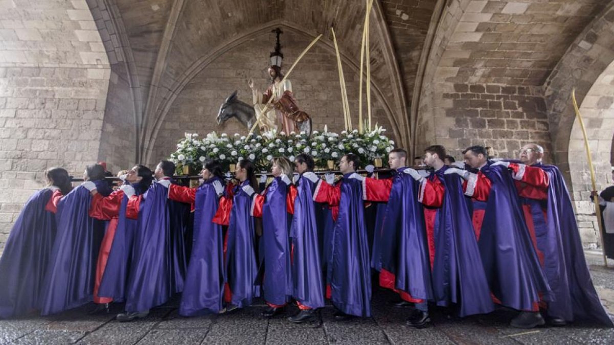 Los cofrades de la Coronación de Espinas y de Cristo Rey llevan en andas el paso de Jesús en la borriquilla.-SANTI OTERO