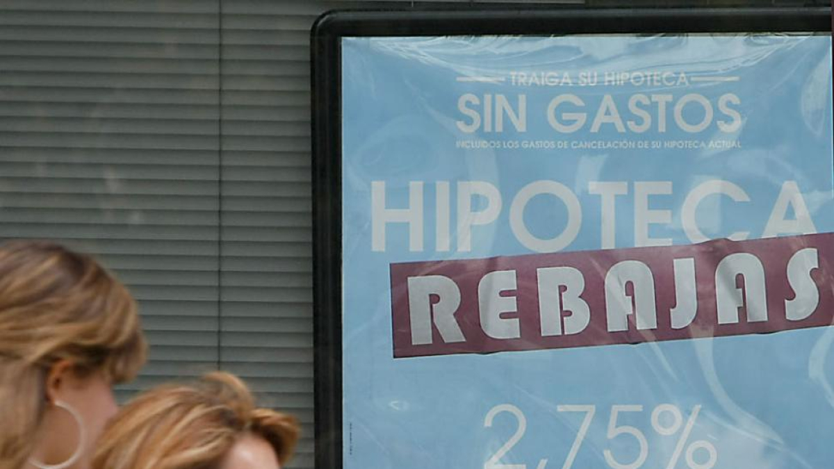 Dos mujeres pasan frente al anuncio sobre hipotecas de una entidad bancaria.-RAÚL G. OCHOA