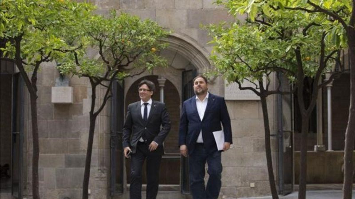 El 'president' de la Generalitat, Carles Puigdemont, y el 'vicepresident', Oriol Junqueras.-ALBERT BERTRAN