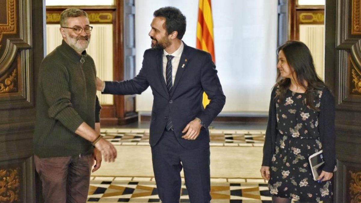 El presidente del Parlament, Roger Torrent, saluda a los diputados de la CUP Carles Riera y Maria Sirvent.-FERRAN SENDRA