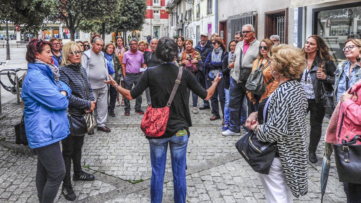 Un grupo de turistas atiende durante una ruta con guía turístico en Burgos.
