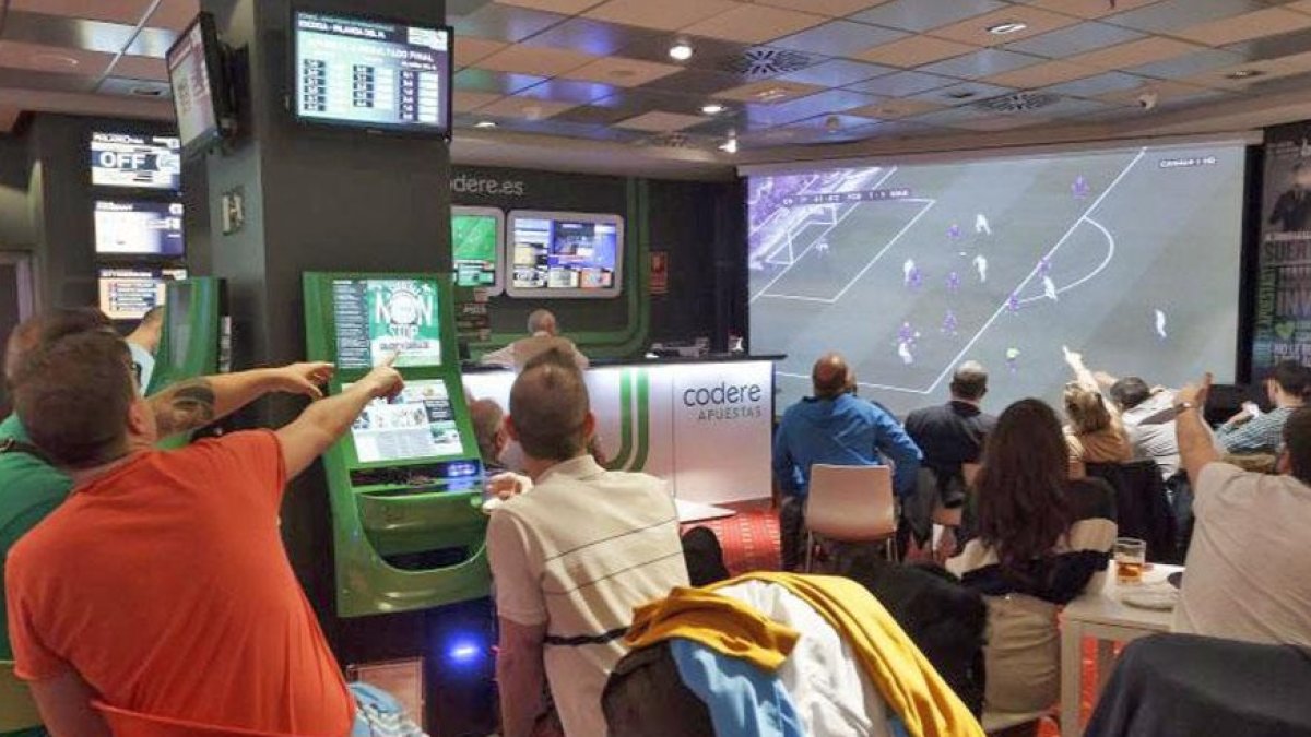 Imagen de archivo de varios jóvenes en una sala de apuestas deportivas. EL MUNDO
