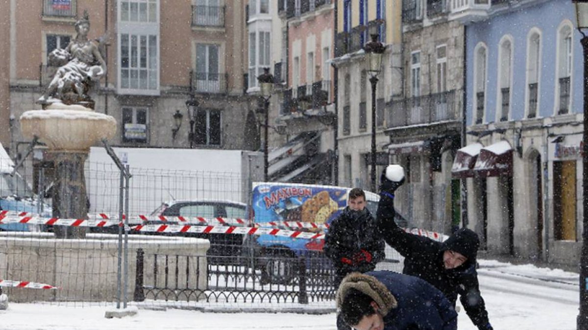 Unos jóvenes juegan con la nieve en la plaza de La Flora.-RAÚL G. OCHOA