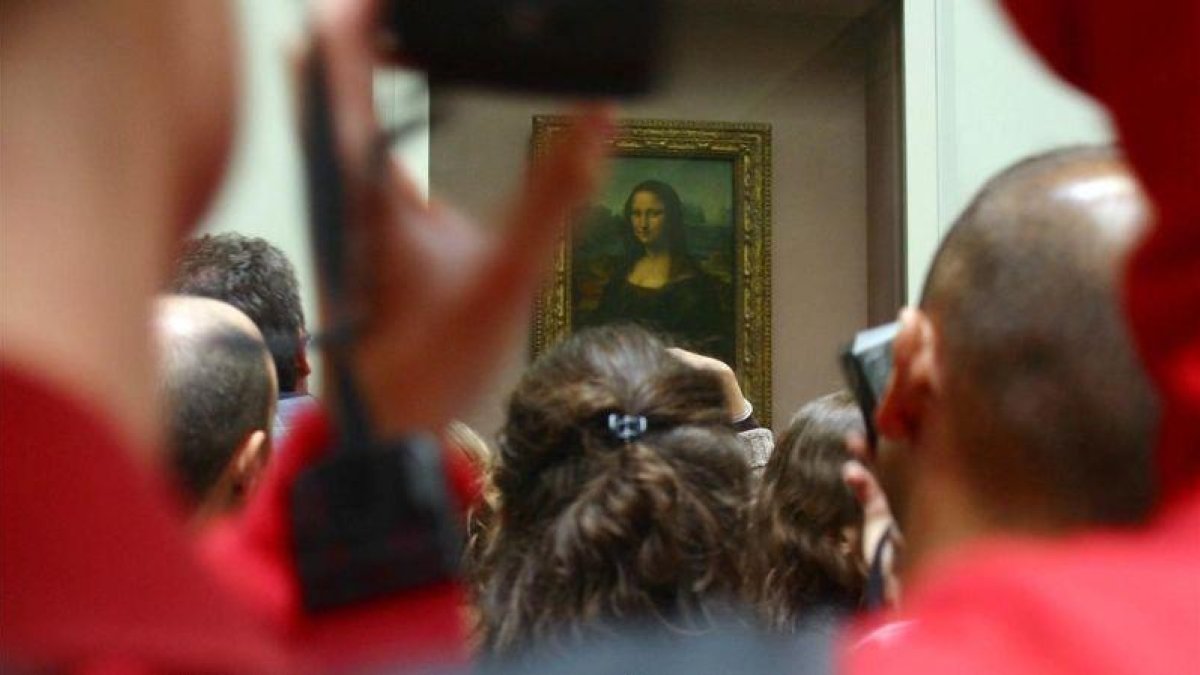 Aglomeración de visitantes frente a La Gioconda, en el Museo del Louvre.-DANIEL MORDZINSKI