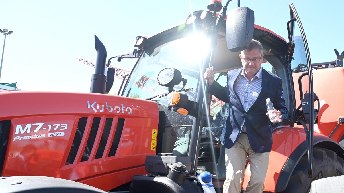 El consejero de Agricultura, Gerardo Dueñas, se baja de un tractor en la feria de maquinaria. ICAL