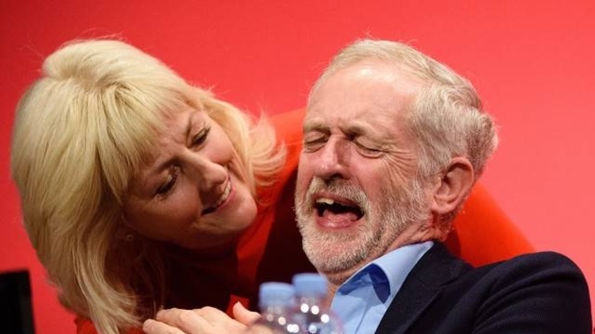El líder del partido Laborista, Jeremy Corbyn, bromea con una miembro de la formación durante el congreso en Brighton.-AFP / LEON NEAL