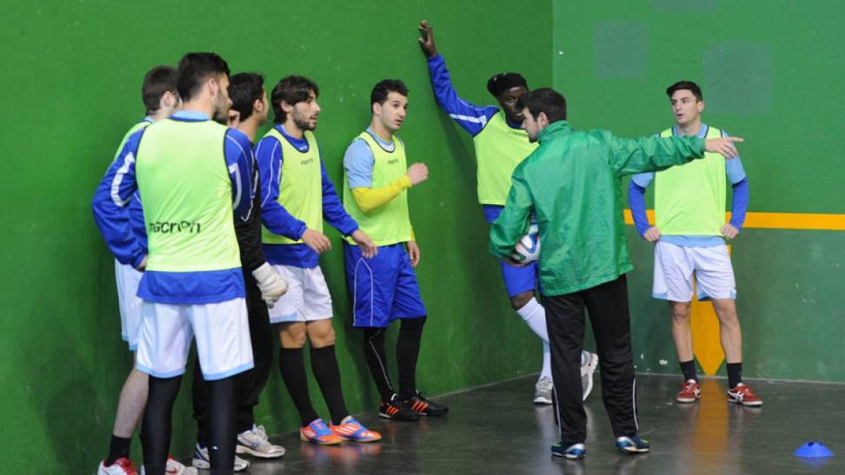 Varios jugadores del Burgos en el frontón de Lavaderos reciben instrucciones de Eduardo del Moral.-ISRAEL L. MURILLO
