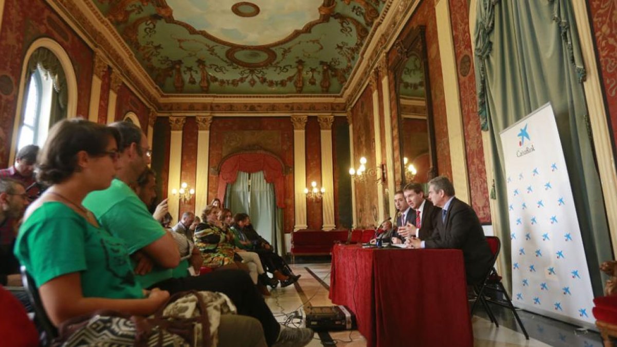 Los miembros de la Plataforma de Afectados por la Hipoteca (izquierda) y los grupos políticos asistieron a la firma del convenio entre el Ayuntamiento y la entidad bancaria.-RAÚL G. OCHOA