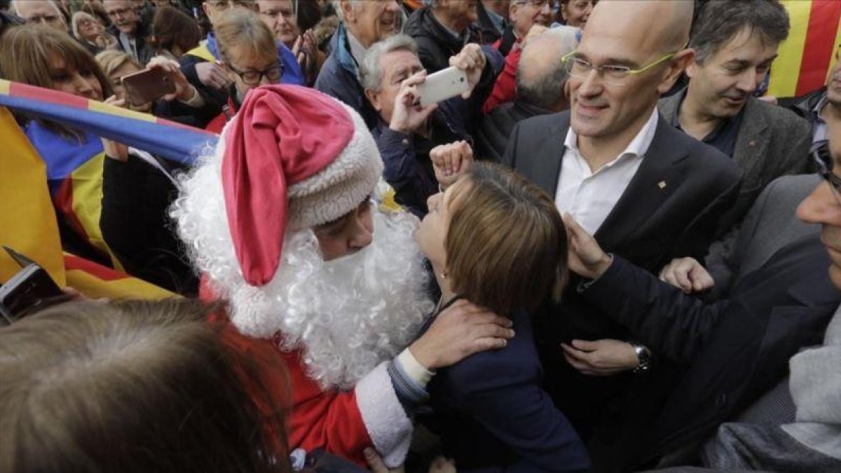 Un 'papá noel' saluda a Carme Forcadell a su salida del TSJC.-FERRAN NADEU