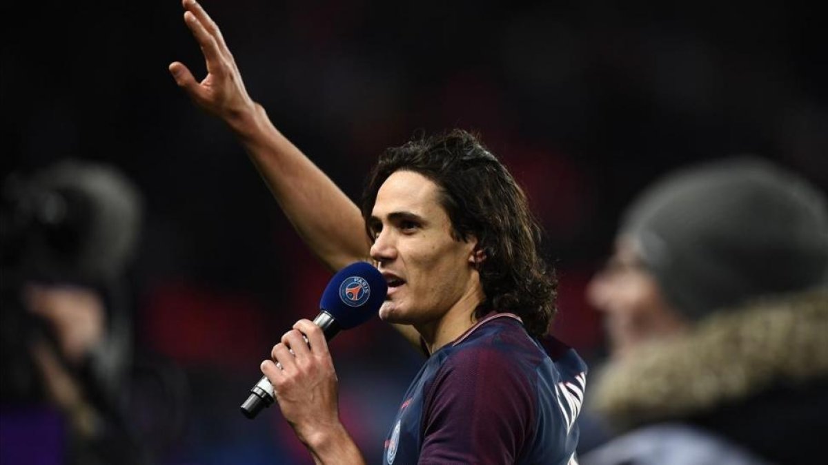 Cavani, con un micrófono, se dirige a la afición del PSG después de batir el récord histórico de goles del equipo.-AFP