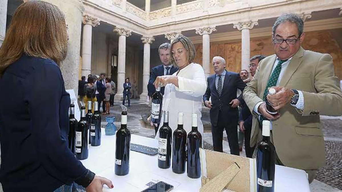 La consejera Milagros Marcos acompañada por el alcalde de Burgos y el subdelegado de la Junta en Burgos observan vinos en un puesto.-RAÚL G. OCHOA