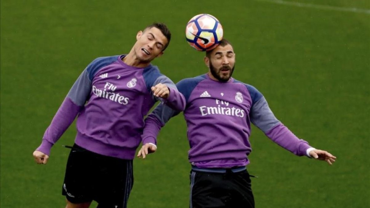 Cristiano Ronaldo y Benzema disputan el balón durante el entrenamiento de este sábado en la ciudad deportiva de Valdebebas.-EFE / JUANJO MARTÍN