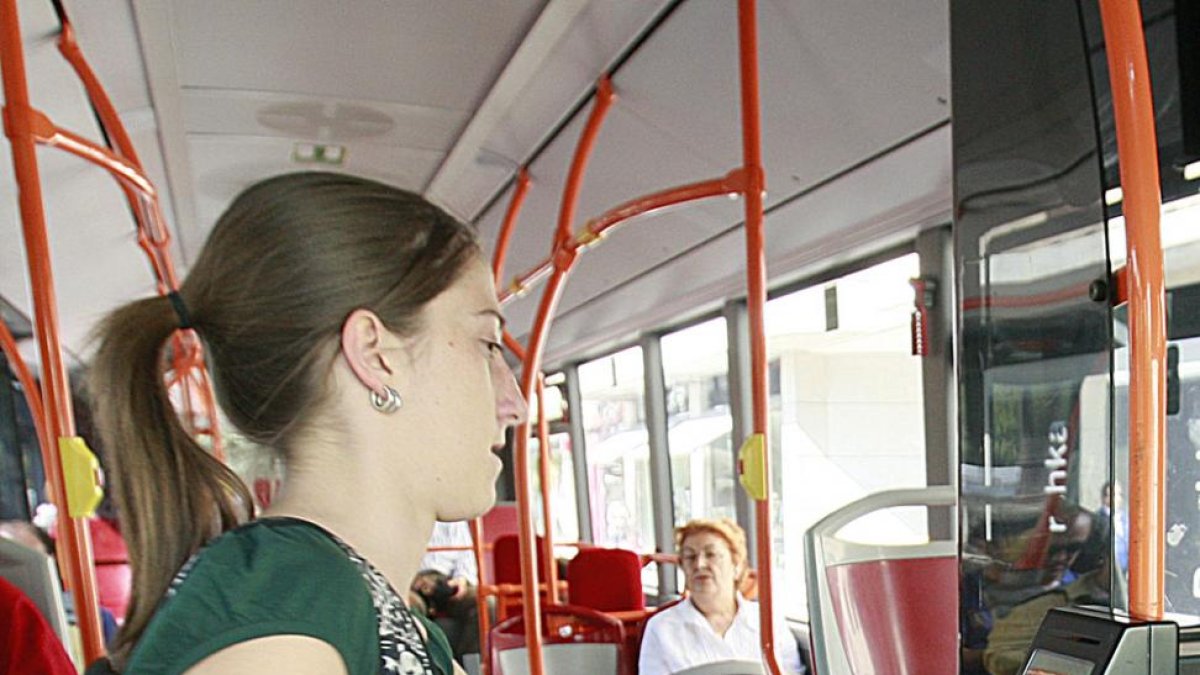 Una viajera pasa su tarjeta en el lector para utilizar el autobús urbano.-RAÚL G. OCHOA