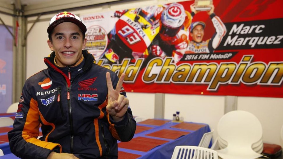 Marc Márquez (Honda) hace la señal de victoria ante un cartel que había en Phillip Island que le felicita por su título.-REPSOL MEDIA / JAIME OLIVARES